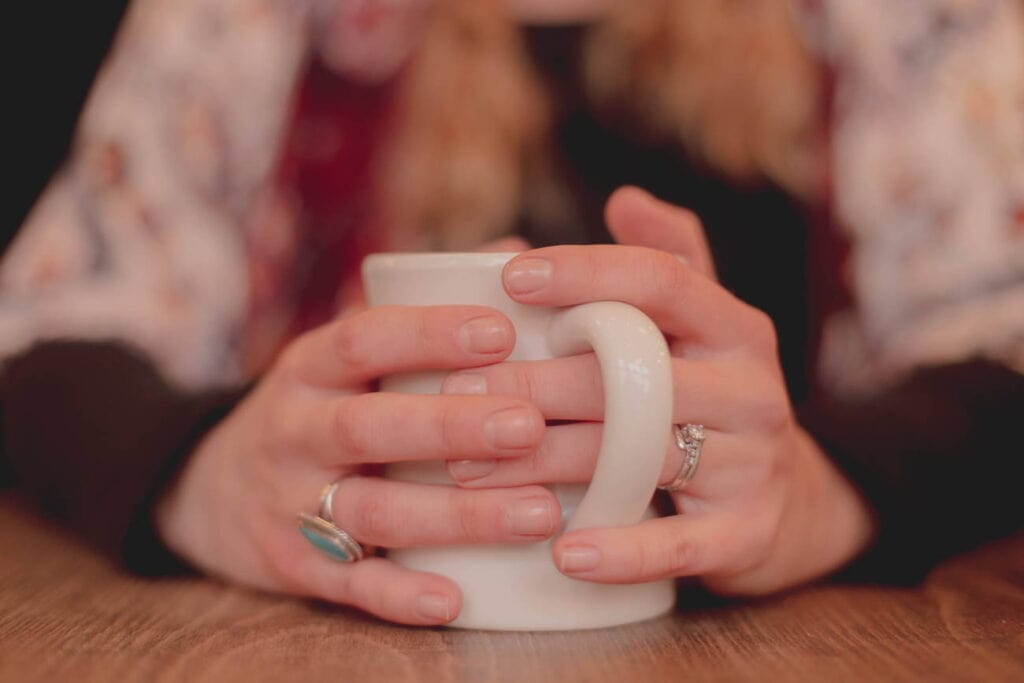 Symbolbild - Frau, die eine Tasse umklammert - für eine Krise